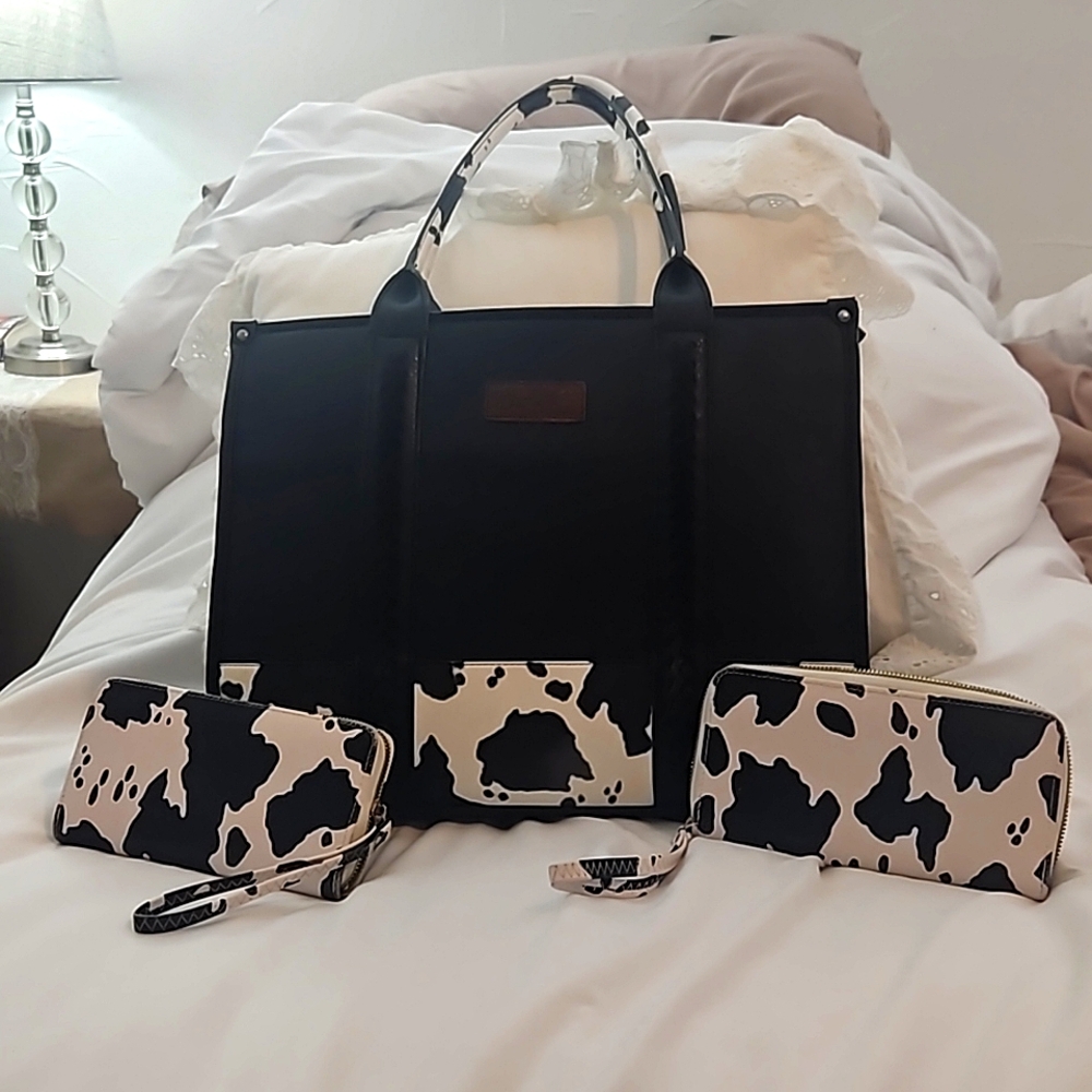 Black and white cow print Wrangler purse and two wallets.